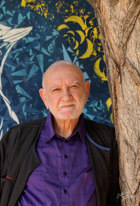 Henri Gougaud Henri Gougaud devant une fresque représentant un oiseau qui s'envole dans le parc de la baleine bleue à Paris